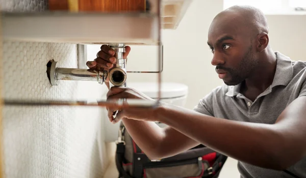 a male plumber fixing a bathroom faucet in Richardson, TX - Richardson, TX
